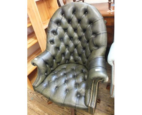 A green leather button back swivel armchair