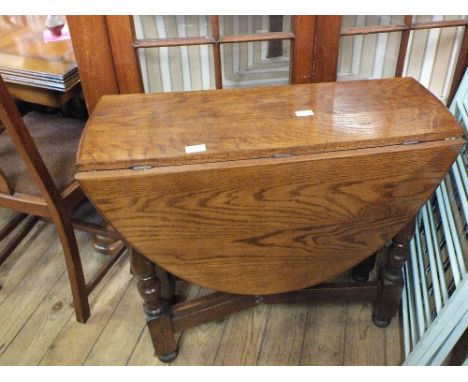 A mahogany standard lamp and an oval gate leg table