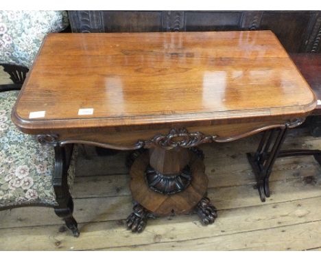 A 19th Century rosewood fold over top card table on shaped column, platform base and claw feet