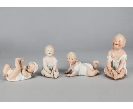 Four Gebruder Heubach babies, two seated, one high coloured —6in. (15cm.) high; one lying on back and one crawling, in nightd