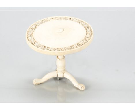 A fine 19th century ivory dolls’ house tripod occasional table, with finely carved floral edge to tilt top, turned pedestal o