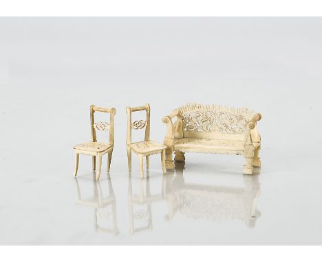 Small scale bone dolls’ house furniture,  a sofa with intricate pierced back and seat —2½in. (6.5cm.) wide; and two similar c