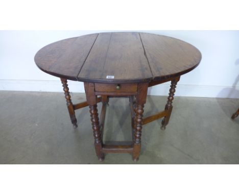 An 18th century oak gateleg table on bobbin turned supports with a drawer - Height 72cm x 81cm x 98cm 