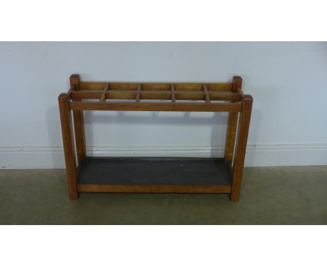 A double row stick stand with ten compartments, drip tray below, raised on square supports - Height 60cm x 91cm x 31cm 