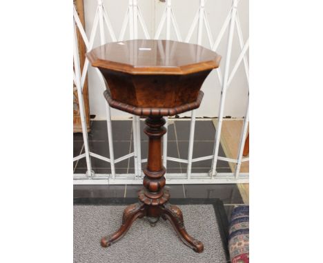 A mid Victorian walnut and mahogany teapoy, the octagonal top on a turned column and three tripod legs