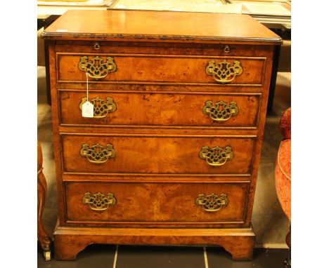 A George I style burr walnut chest of drawers, having a brushing slide over four long graduated drawers, bracket feet