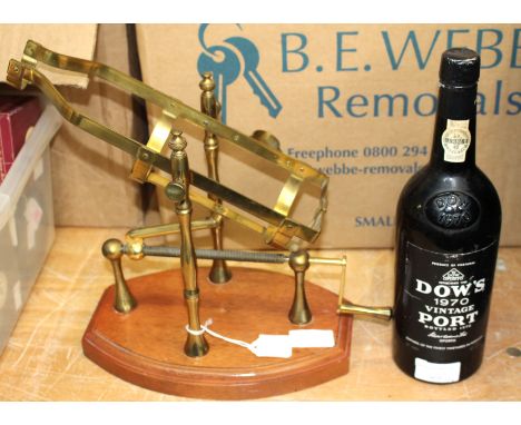 A 1970 Dow's vintage port bottle with brass and wood mechanical decanter