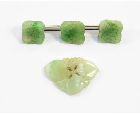 A white metal mounted green jade brooch, having three jade panels, each carved with stylised four peal flowers, together with