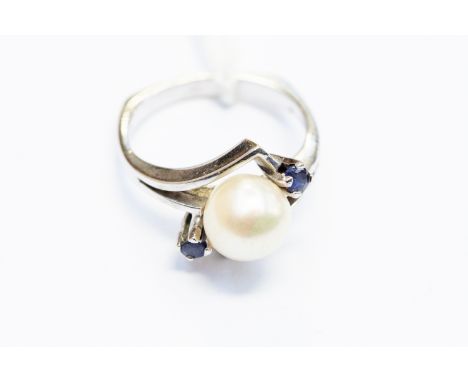 A cultured pearl and sapphire ring, set with a single pearl approx 7.5mm, with claw set sapphires either side, unmarked white