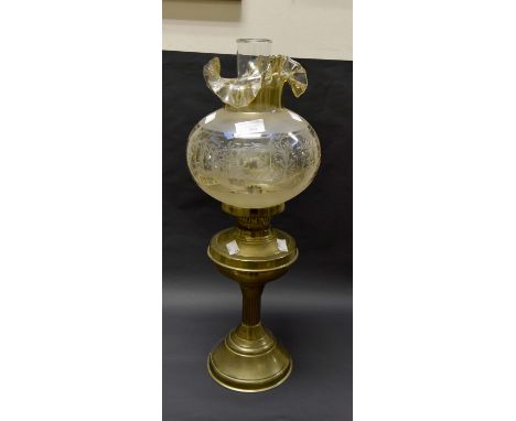 A brass twin burner oil lamp with funnel and glass globe