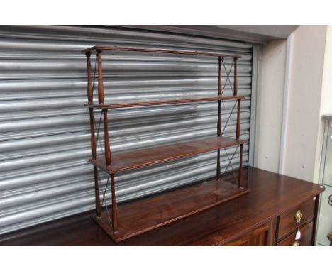 An early 20th Century mahogany wall hanging shelf, each tier raised on turned supports