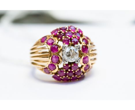 A yellow metal, diamond and ruby dress ring, having central round old cut diamond in raised setting, (approx. 0.5 carats) wit