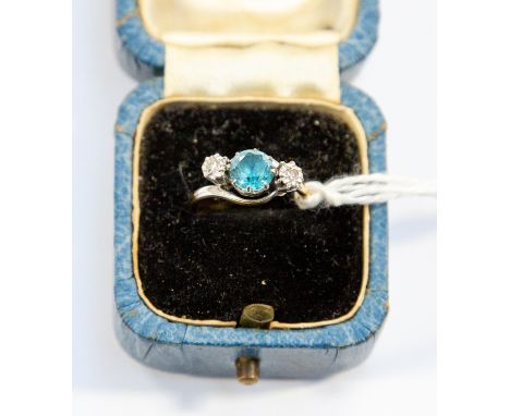 A blue zircon and  9ct gold  set ring, round zircon set to the centre with two small illusion set diamonds set either side, r