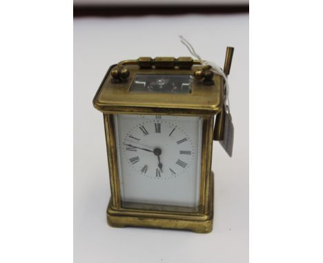 A late 19th Century brass cased carriage clock, having a white enamelled dial, black Roman numerals, four pillared movement, 