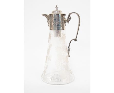 A Victorian silver mounted glass claret jug, the rim engraved with scrolling vine leaves and grapes beneath hinged domed cove