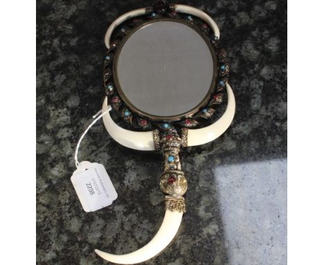 An early 20th century Austro-Hungarian oval gilt metal mirror, embellished with turquoise and ruby coloured glass cabochons a