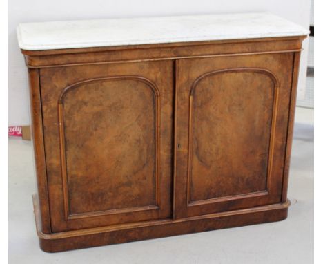 A Victorian marble-topped figured walnut floor-standing press cupboard, the two arched panel doors open to reveal press slide