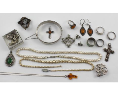 A quantity of silver and costume jewellery to include a string of faux pearls, three white metal charms, faux amber pendant, 
