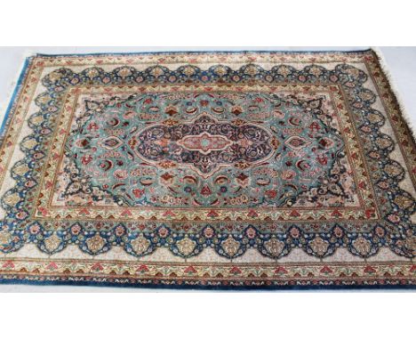 A machine-knotted silk Tabriz carpet with scrolling arabesques, central medallion and spandrels to a light blue ground within