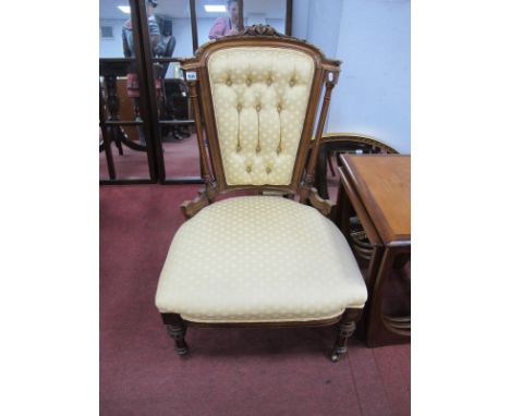 A XIX Century Nursing Chair with scroll carved cresting, beaded ring decoration to reeded supports, re upholstered in a cream