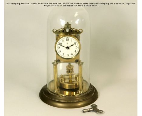 ANNIVERSARY CLOCK. A brass anniversary clock by Badische Uhrenfabric, beneath glass dome. Height 32cm.