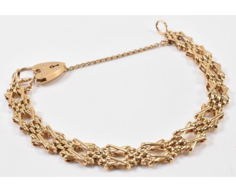 A gold bar and gate chain bracelet with heart padlock clasp. The bracelet having watch links interspersed with X links. Marke
