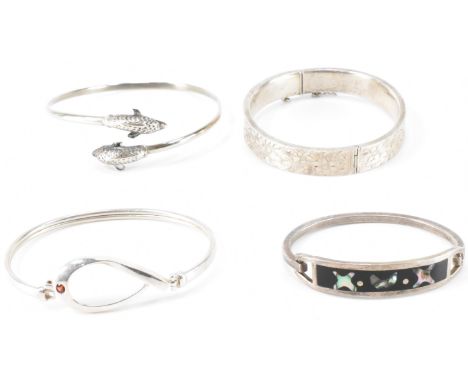 An assortment of four silver bracelets to include a hallmarked silver bracelet with incised floral decoration and tongue and 