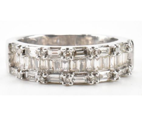 A hallmarked 9ct white gold and diamond ring. The ring being set with three rows of baguette cut diamonds and round cut diamo