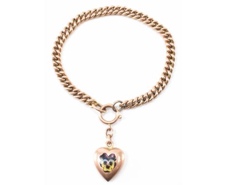 A Victorian gold enamel gold curb chain bracelet with a heart pendant with enamel pansy flower decoration. Marked 9ct to chai