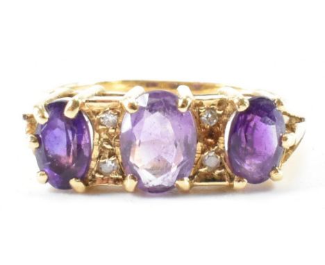 A hallmarked 18ct gold amethyst and diamond ring. The ring being set with three oval cut amethysts with four diamond accent s