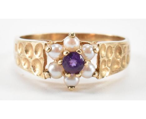 A hallmarked 9ct gold amethyst and pearl ring. The ring having a central round cut amethyst to the centre with a halo of half