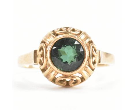 A gold and tourmaline ring. The ring being set with a round cut green tourmaline in a pierced mount. Marked 585 to the shank.