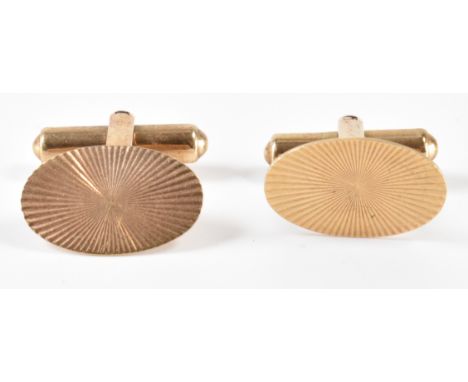 A pair of hallmarked gold gents cufflinks. The heads being decorated with incised sunbursts and being of oval form. Marked 37