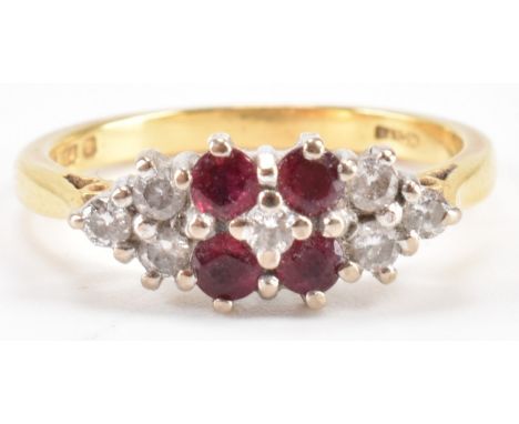 A hallmarked 18ct gold ruby and diamond cluster ring. The ring being set with seven round cut diamonds and four round cut rub