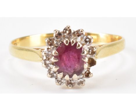 A hallmarked 18ct gold ruby and diamond ring. The ring being set with an oval cut ruby with a halo of round cut diamonds. Hal