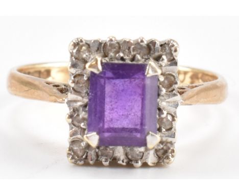 A hallmarked 9ct gold amethyst and diamond ring. The ring set with an emerald cut amethyst framed by diamonds in an illusion 