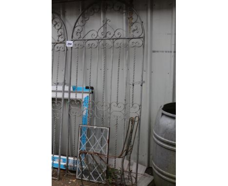 An ornate ironwork gate along with 2x bench ends
