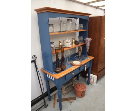 A kitchen dresser with plate rack and tile top