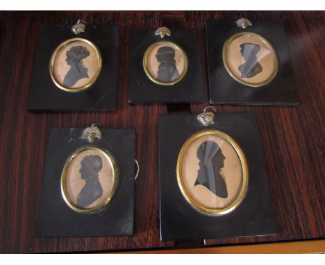 A pair of early 19th century pen and ink portrait miniatures of a gentleman and a lady and three more pen and ink portrait mi