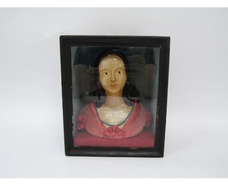 A papier-mache half-portrait model of a lady in a red silk costume, contained in an ebonised wall-hanging box with a glazed f
