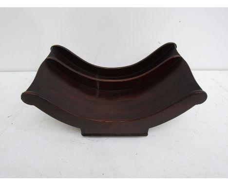 A Regency mahogany cheese coaster, the dipped and divided interior with baluster turned ends, the platform base with brass ro