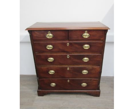 A late Georgian tall mahogany split chest of two short, over four long graduating drawers with oval brass handles, flanked by