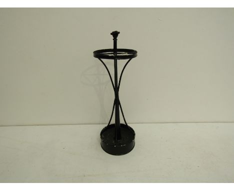 A circular metal stick / umbrella stand with circular drip pan and circular cross-sectioned top centred by a raised hand clen