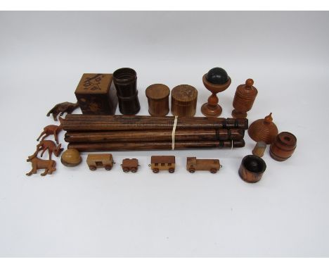 A group of treen to include a puzzle box, eight turned pegs, a turned wood dice shaker, and a cup and ball game