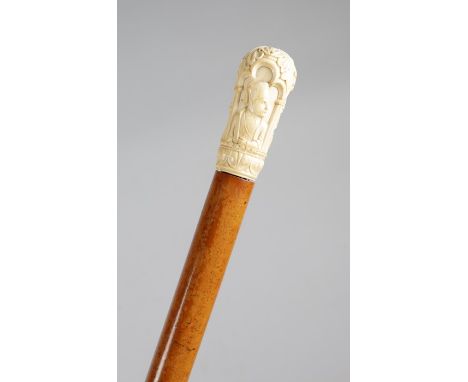 An ivory handled walking cane in the Renaissance revival style, the pommel carved with leaves and three trefoil arches, with 