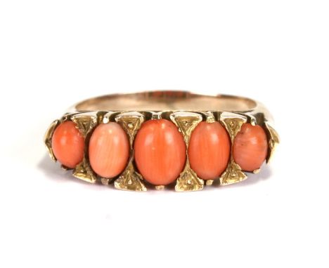 A yellow coloured metal and coral half hoop ring, approx UK size 'O'.