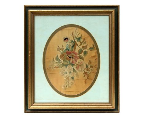 A 19th century oval silk needlework embroidery depicting flowers, framed &amp; glazed, 24 by 30cms (9.5 by 12ins).