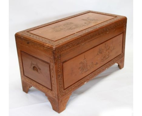 A Chinese camphorwood trunk carved with river scenes, 102cms (40ins) wide.