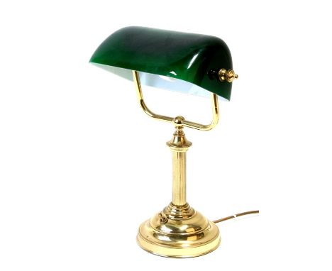 A brass bankers lamp with green glass shade