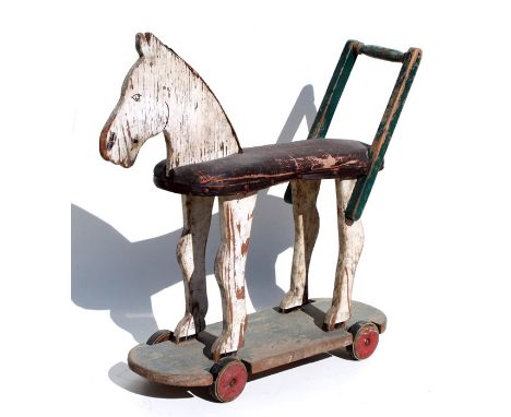 A vintage distressed painted pull-along horse, 69cms (27ins) long.